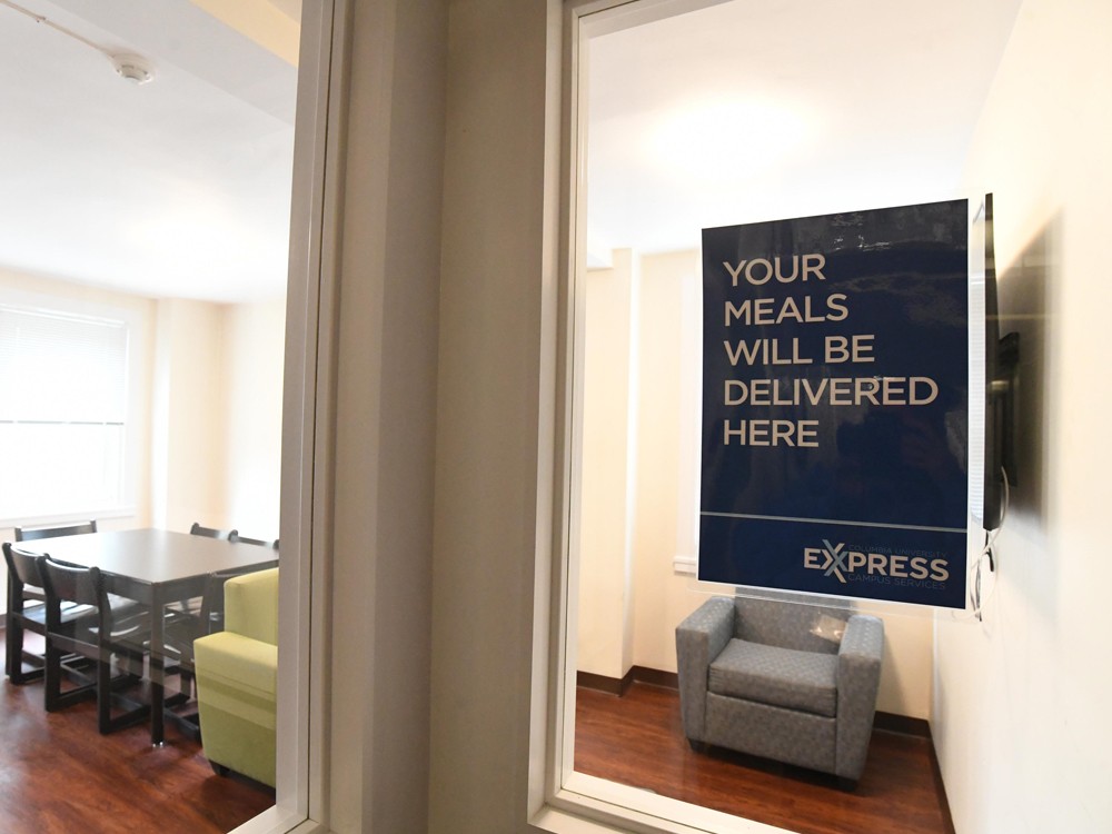 A sign attached to the window of a student lounge that reads, "Your meals will be delivered here - Express."