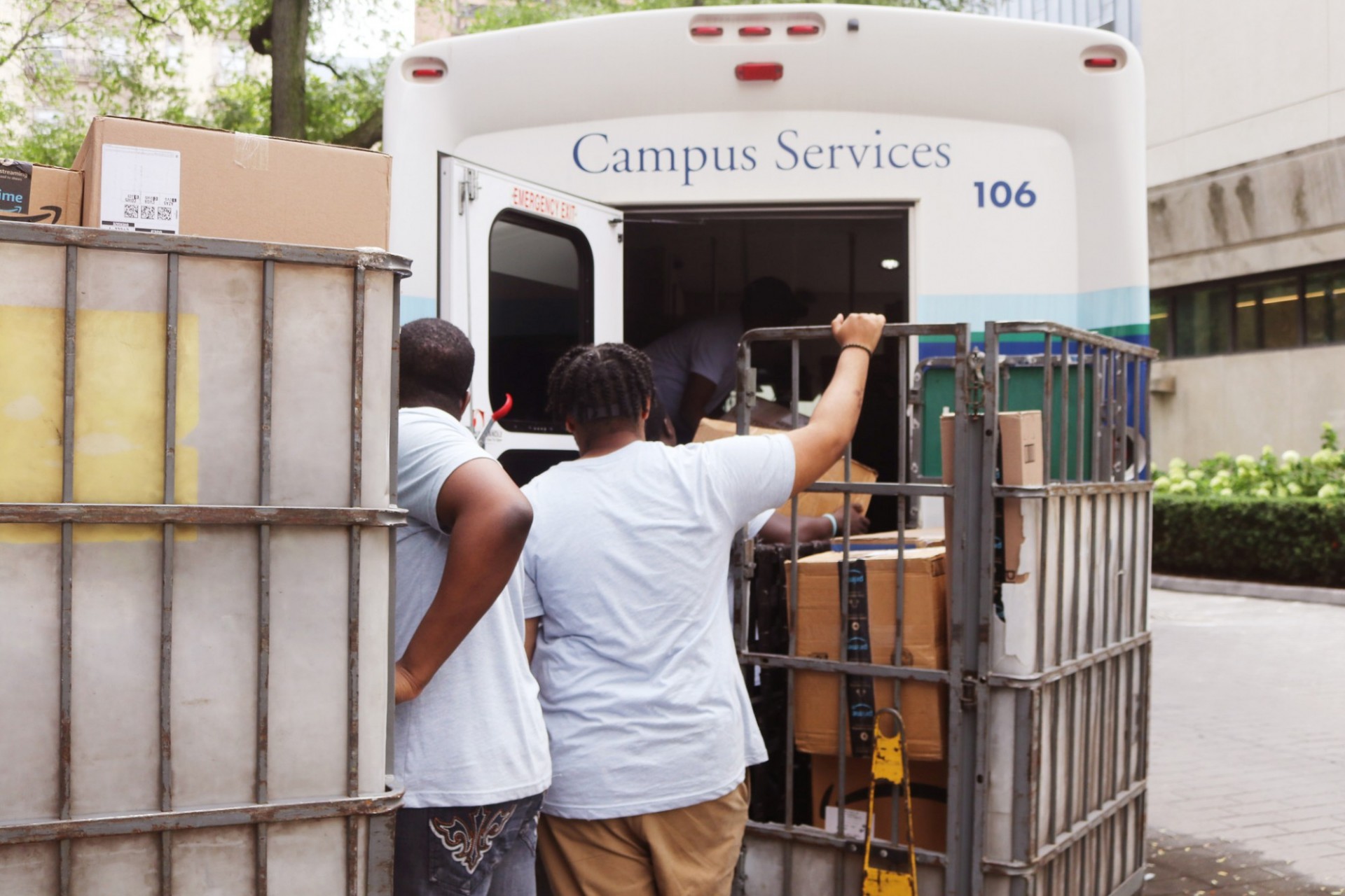 Employees unloading packages from Campus Services vehicle