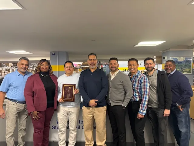 Columbia Mail management staff members pose with the award at the Student Mail Center