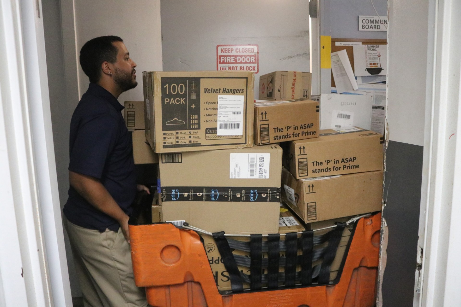 Employee wheeling a cart full of packages