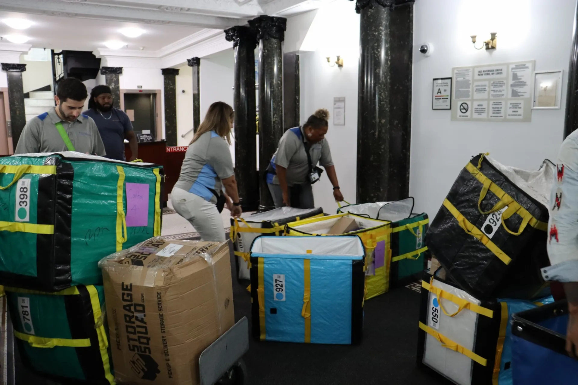 Mail team organizing packages by floor in Carlton Arms lobby