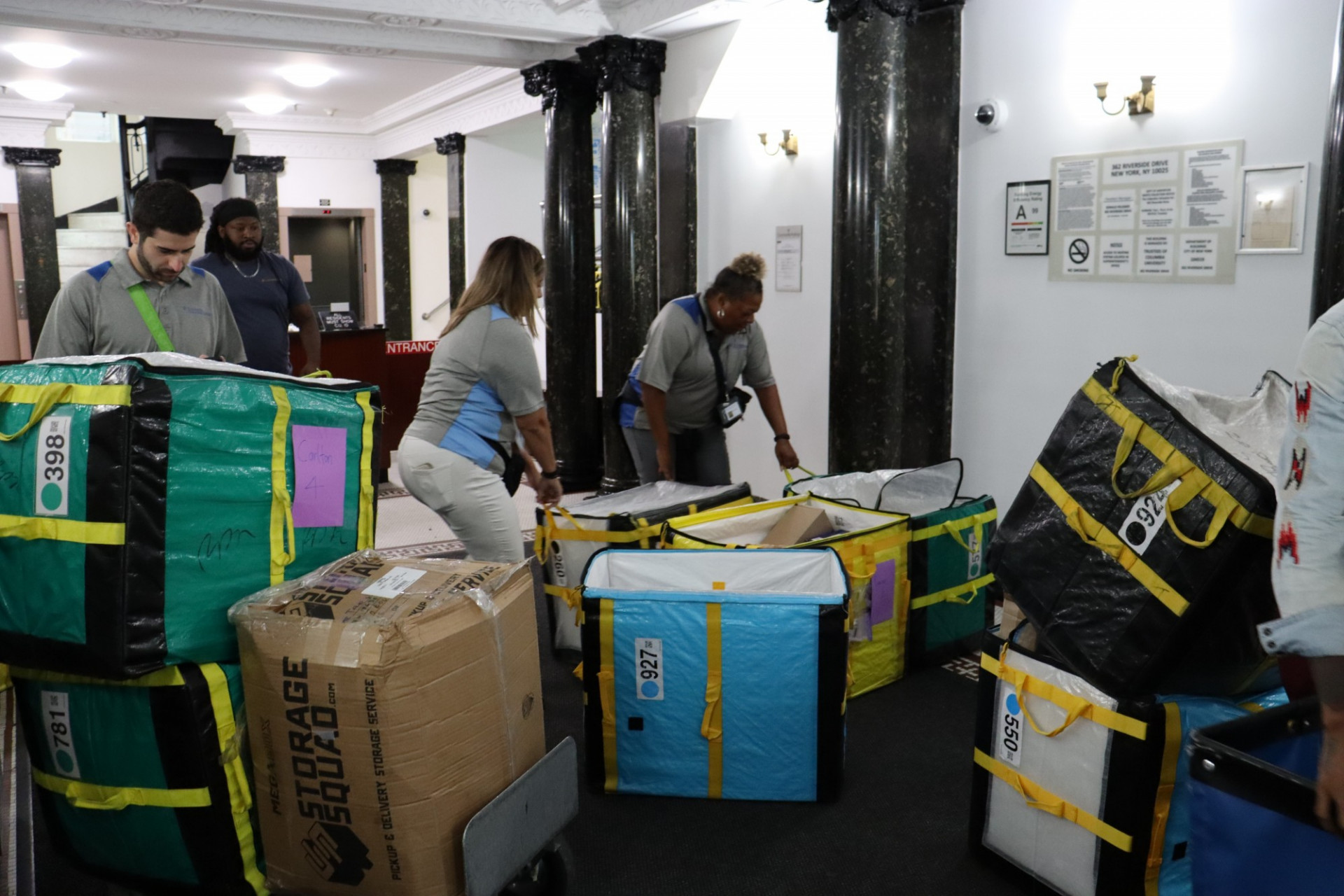 Mail team organizing packages by floor in Carlton Arms lobby