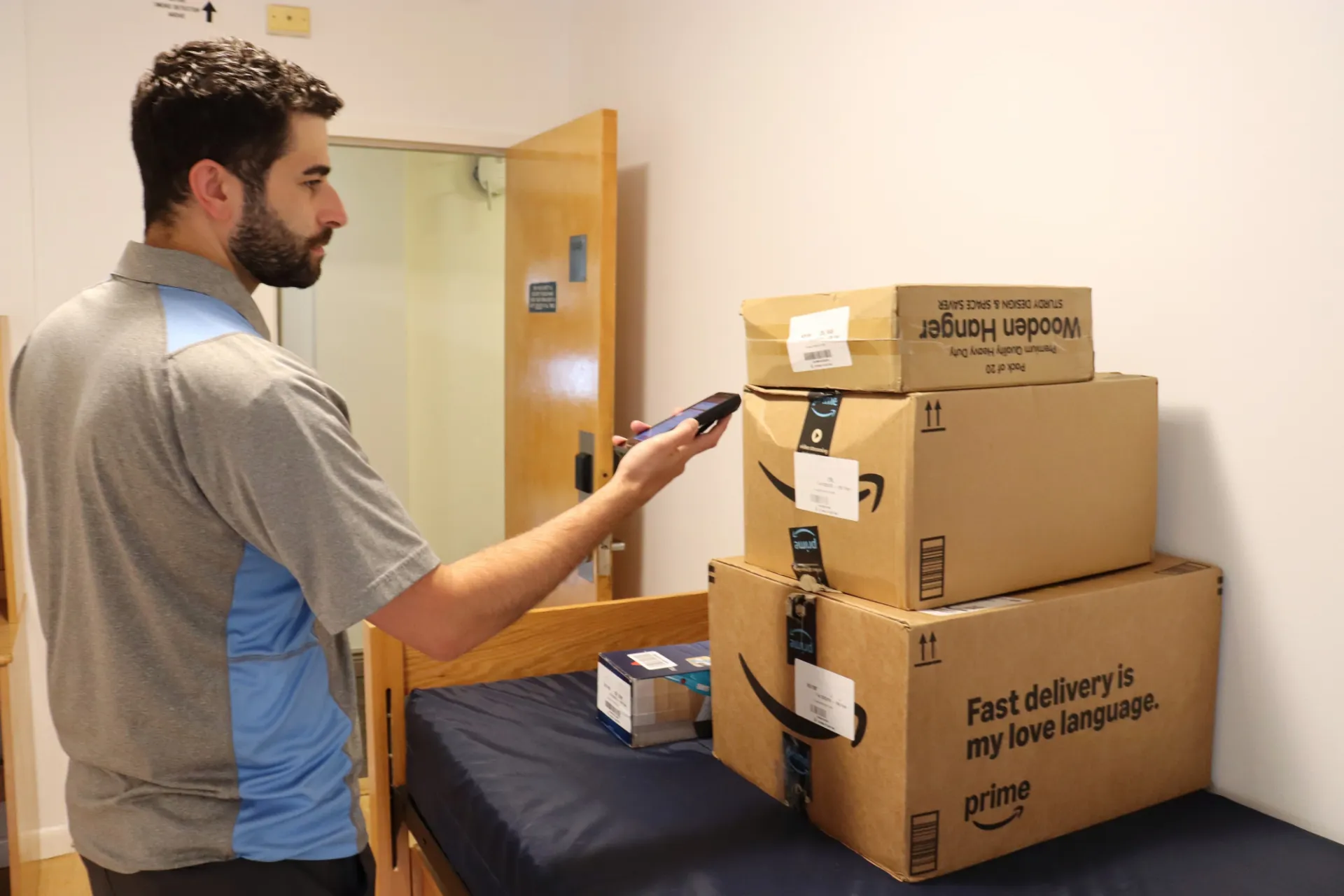 Packages on student bed being scanned to complete delivery