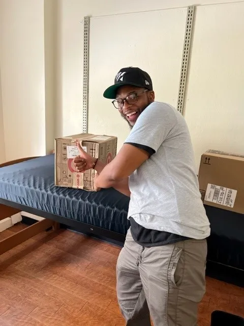 A member of the Student Mail team places a package in room.